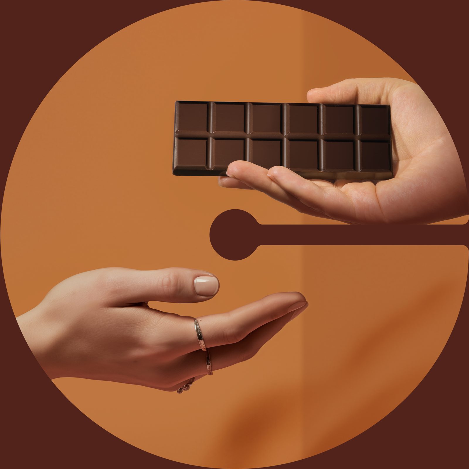 Hands passing a chocolate bar inside a letter C