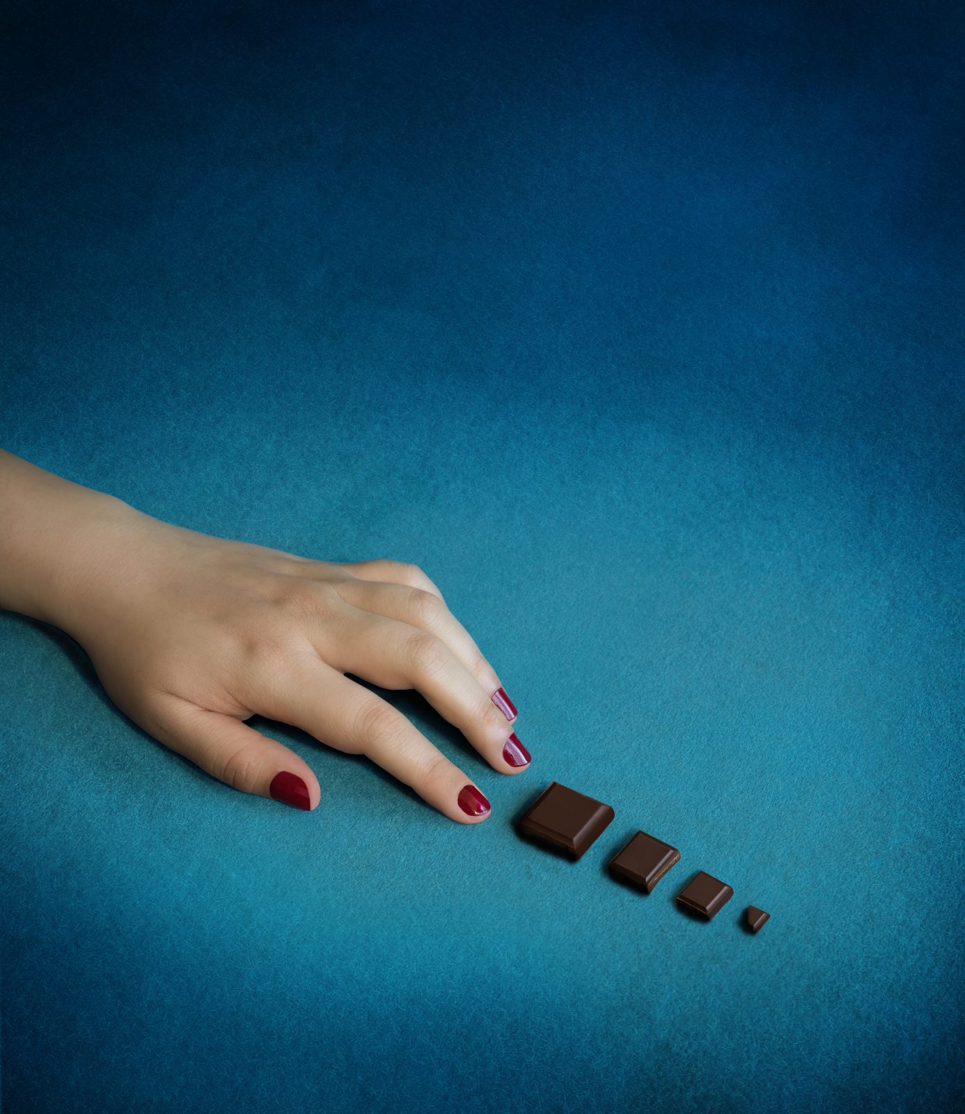 Hand reaching for bite-size chocolate pieces